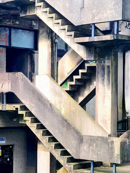 A concrete stairway at the back of a 1960s Brutalist student union building.