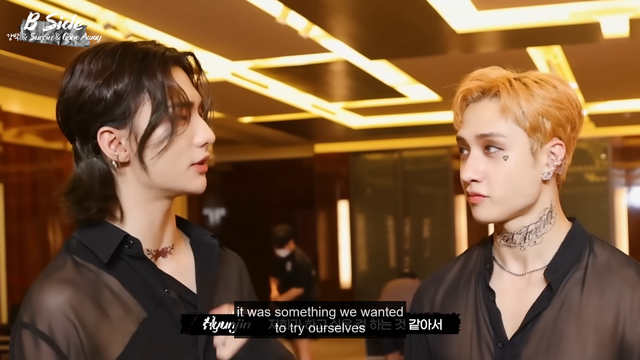 Bang Chan looks at Hyunjin, who says, "It was something we wanted to try ourselves"