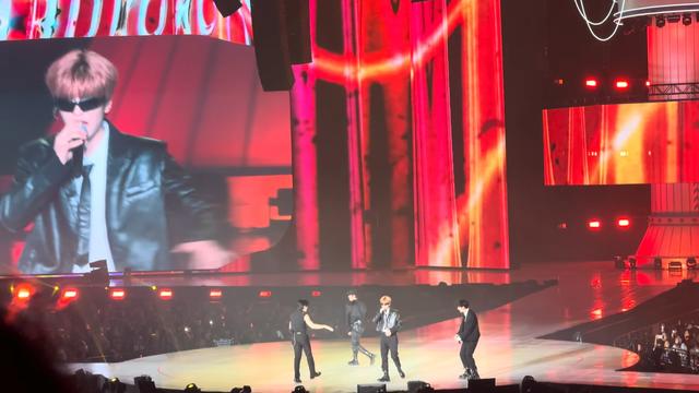 Stray Kids members performing Muddy Water at the PILOT fanmeeting, with Seungmin on the big screen