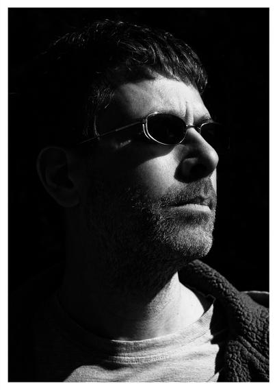 Black and white self-portrait with my face highlighted on one side while the rest of the image is black.