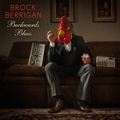 Album cover of Brock Berrigan – Backwards Blues featuring a man in a chicken mask sitting on a couch with a drink and cigarette, surrounded by music equipment in a vintage setting