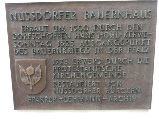 Eine Erinnerungstafel am Nussdorfer Bauernhaus, dass ein Museum für den Bauernkrieg beinhaltet. Text: "Erbaut um 1500 durch den Dofschöffen Hans Hohl. Kerwe-Sonntag 1525 Ausgangspunkt des Bauernkriegs in der Pfalz. 1978 Erwerb durch die Protestantische Kirchengemeinde. Restauriert von Nussdorfer Bürgern. Pfarrer-Lehmann-Archiv. (War leider nicht offen)