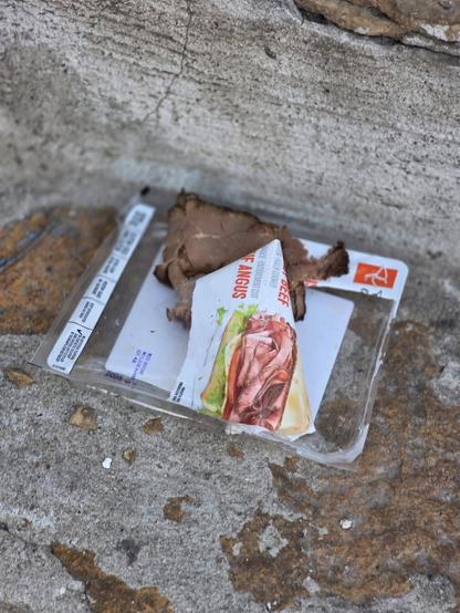 A package of open roast beef on the street
