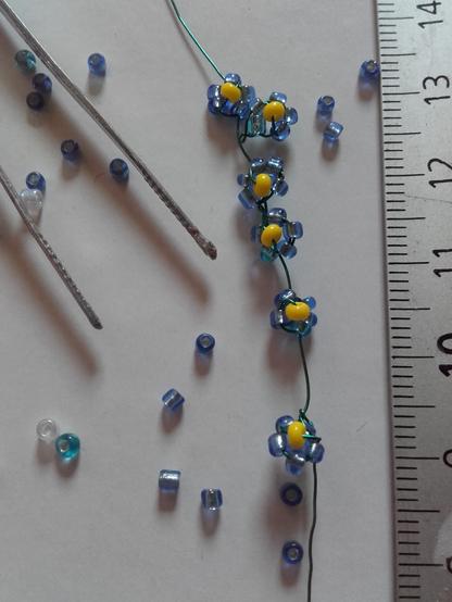 Even smaller flowers with a transparent blue. I need tweezers to make them. A ruler beside shows that one flower is smaller than 5 mm.