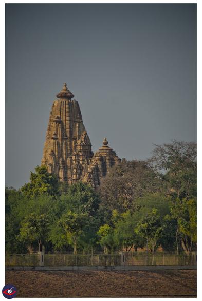 photo taken from far of a temple, and there is trees in front of it.