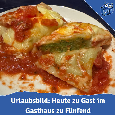 Eine gefüllte Maultasche liegt aufgeschnitten auf einem weißen Teller. Die Maultasche ist mit einer roten Tomatensoße bedeckt und der aufgeschnittene Teil zeigt eine grüne Füllung im Inneren. Die Pasta ist goldbraun überbacken mit geschmolzenem Käse. Das Bild ist in Nahaufnahme aufgenommen und zeigt die saftige, appetitliche Textur des Gerichts. Am unteren Bildrand ist ein blauer Designelement-Streifen zu sehen mit der weißen Schrift 'Urlaubsbild: Heute zu Gast im Gasthaus bei Fünfend'
