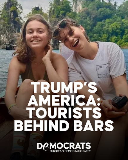 Photo of two young women sitting side by side and smiling at the camera. It appears they're in a boat just off the shore. Thick vegetation is visible behind them.

Text over the lower part of the photo reads:

TRUMP'S 
AMERICA: 
TOURISTS 
BEHIND BARS

Democrats
European Democratic Party