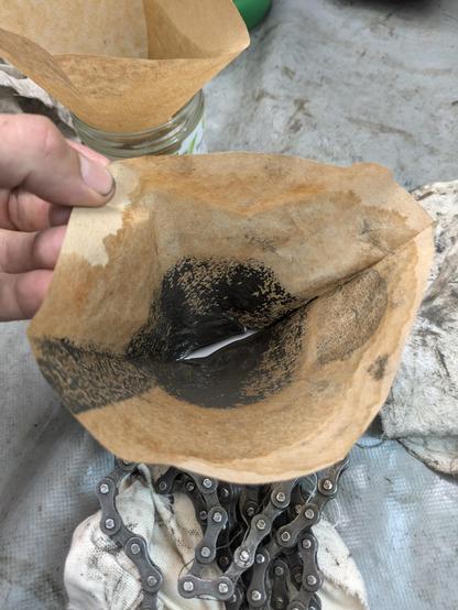 A wet brown coffee filter with a lot of greasy black smudge.