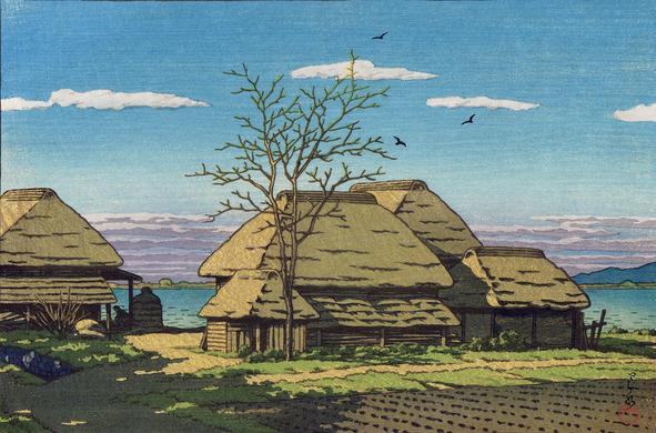 A view of a traditional style rural farm in Ibaraki Prefecture. In the foreground, a vegetable field has been planted in tidy rows. Nearby, a tall tree is still leafless. Beyond, a group of thatched-roof farm buildings stands on the shore of what is probably Lake Kasumigaura; on the left, a single person can just be seen in shadow, stooped at some unseen task. Above, a trio of birds wheel in a bright blue sky populated by a few puffy white clouds. The sun illuminates the scene at an angle, casting the shadows of unseen trees across the farmyard.