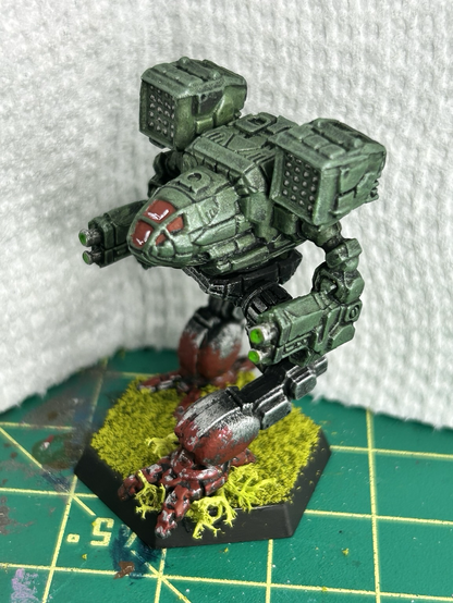 a Timberwolf mech, painted with a green torso and red paint splashed on the feet