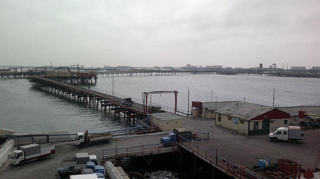 Vue panoramique de Neft Daşları, une ville industrielle unique construite sur des plateformes offshore dans la mer Caspienne. L'image montre des structures industrielles, des bâtiments, des ponts et des passerelles s'étendant sur l'eau, illustrant l'ingéniosité humaine dans l'exploitation pétrolière en milieu marin.