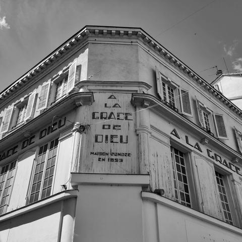 Vue en contrebat d’un immeuble sur lequel est écrit « A la grace de Dieu » maison fondée en... » (l’année est illisible).