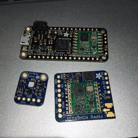 "This picture shows a collection of electronic devices, including a printed circuit board (PCB) with various components, a breadboard with connections for experimentation or prototyping, and two modules with visible blue lights, which could indicate that they are powered on. The setup suggests an interest in electronics, possibly hobbyist or educational activity related to programming or hardware development."