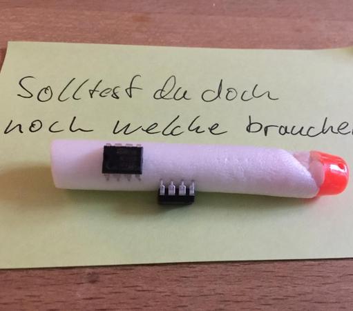 "This picture shows a nerf gun dart with two integrated circuits pinned into it. A hand written note says: In case you need some more.