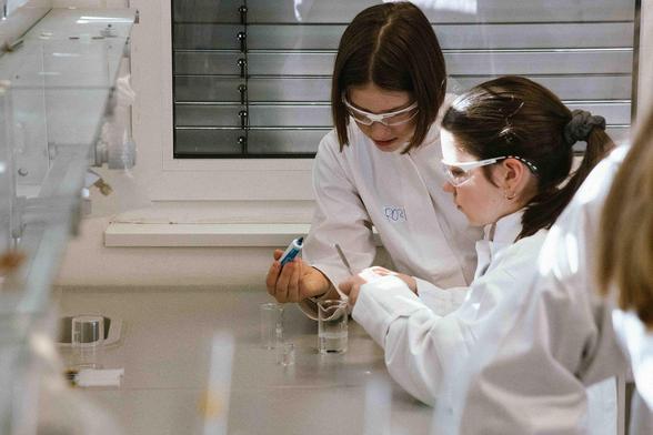 Zwei Kinder im Kittel, mit Schutzbrille im Labor. Sie arbeiten konzentriert daran, aus PVA und Borax ein Gel herzustellen.
Bildquelle: Marion Kuka