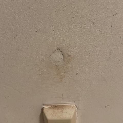 Mit Acryl geschlossenes Bohrloch in einer weißen Wand.