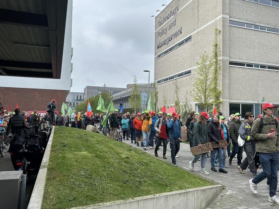 Protestors march in front of the faculty of technology, policy and management
