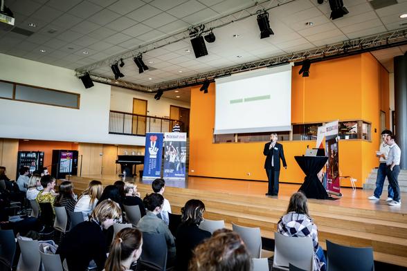 Romée introduceert stellingen voor een zaal jongeren.