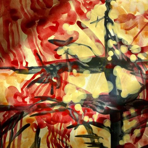 A close-up shot of the acrylic-paint-on-paper sketch showing the almost black skeleton of a burnt out tree engulfed in yellow, orange, and crimson red blobs, squiggles, and lozenges in semi-transparent layers, all highlighted under a shaft of sunlight coming from the studio window.