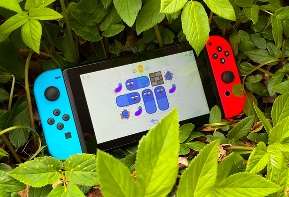 A picture of Munchy Mammals running on a Switch surrounded by plants
