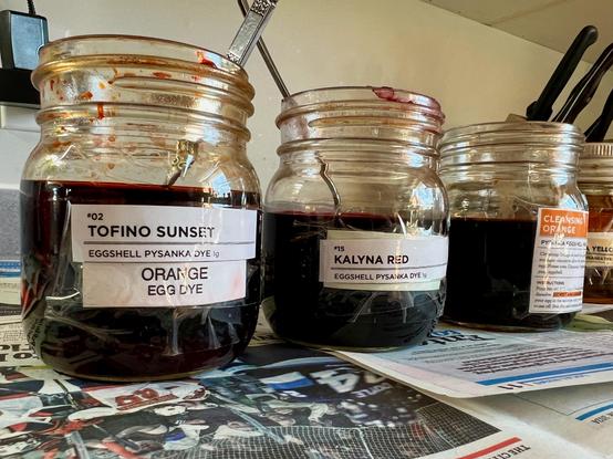 3 jars with various dye colors in them, set up for eggs to be colored.