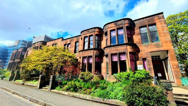 A terrace of red sandstone Glasgow style Edwardian townhouses.