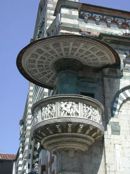 The image features an architectural detail, likely from a historical building, showcasing a decorative balcony or loggia. It has intricate carvings and reliefs of figures, supported by a round column. The structure is adorned with various patterns and colors, suggesting it is a part of a significant or ornate building, perhaps in a Renaissance style. The clear blue sky above adds a striking contrast to the detailed stonework.

Image Credits: Wikimedia / Nessun autore leggibile automaticamente. RicciSpeziari~commonswiki presunto (secondo quanto affermano i diritti d'autore). / CC BY-SA 3.0