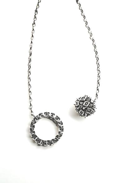 Xover0's new lariat necklace features an intricate spike covered sphere and matching ring at each end of a generous length of chain.