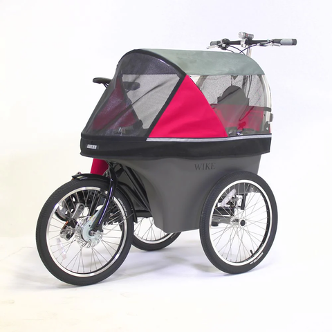 A three wheeled stroller with a bicycle handlebar at the back and a bicycle chain, geared hub, taillight and a saddle on its right side. It has a canopy in grey and pink with windows all around. Left front quarter view.