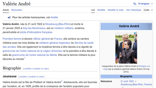 Capture d'écran de l'article Wikipédia en français consacré à Valérie André. L'article présente sa biographie, ses accomplissements en tant que médecin militaire, aviatrice, parachutiste et pilote d'hélicoptère, ainsi que son rôle pionnier en tant que première femme officier général en France. La page inclut également une photographie de Valérie André lors de l'inauguration de la place portant son nom à Brétigny-sur-Orge en 2015.