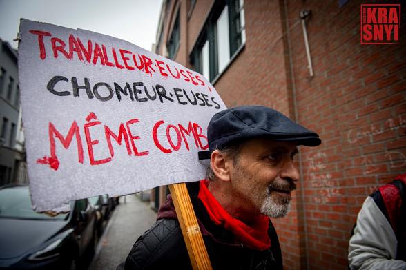 Un manifestant avec une pancarte "TRAVAILLEUR.EUSES, CHÔMEUR.EUSES, MÊME COMBAT"