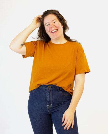 Helen wears a relaxed fit orange t-shirt and jeans.⁠