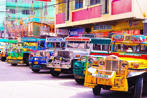Colorful Jeepneys, a popular form of public transport in the Philippines, are parked on a street in Baguio City. Each one is uniquely decorated with bright colors, chrome, and personal messages.
Photo credit: Jeff Jacinto (CC BY 2.0) https://flic.kr/p/psp3s6