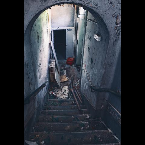 In an abandoned sanatorium, at the top of a stairway , we can see a red cinema seat.urbex photography
