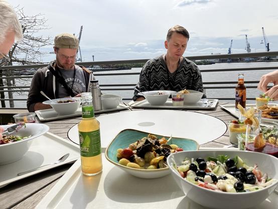 Food on a table with a view to the harbor, with Laurens on the other side of the table