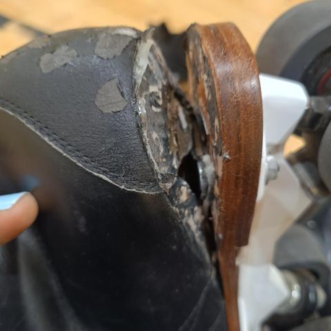 The heel of a quad skate which is coming off the sole.