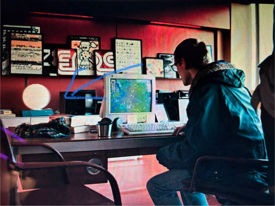 A screen grab from Black Mirror Plaything showing the main character looking at a computer game on a screen, with a SGI Indy in the background.