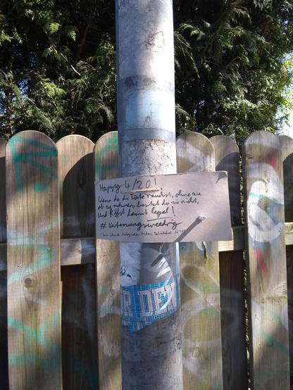 Pappschild an Laterne, im Schild ist ein Loch in dem eine Tüte steckt. Auf dem Schild wird ein Happy 4/20 gewünscht und darüber informiert, dass die Tüte zu rauchen ohne sie abzunehmen völlig legal sei.
Außerdem die Info dass der Joint Tabakfrei, aus biologisch angebauter SensiSkunk und ab 18 ist.