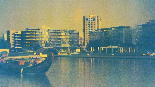 The cityscape of Aveiro with a tourist moliceiro boat in the foreground.
