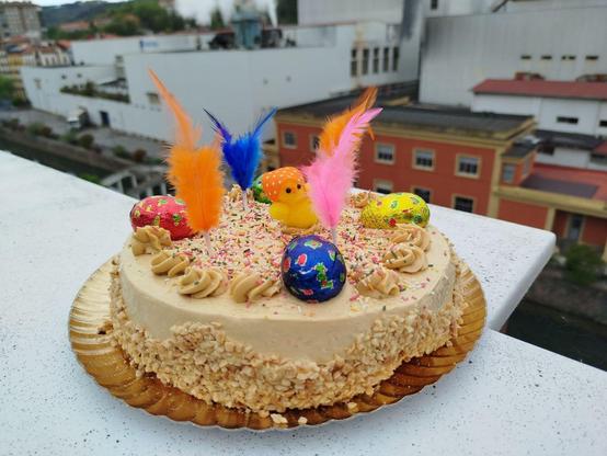 san Marko opil koloretsua, bizkotsoa krema, txokolatezko arraultza eta lumekin. Fondoan ibaia eta papresa fabrika Orereta/Errenterian.