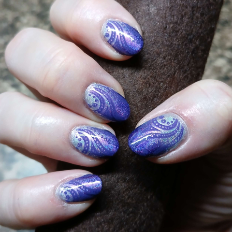 Photo of my nails on my right hand. Holographic purple gradient that's very pale purple at the cuticles, and royal purple at the tips. A creme purple swirl and dot pattern is stamped over the gradient. Nails are "long" as far as I'm concerned, since they go past the finger tip, but are "short" compared to what most people wear as long nails. Tips are rounded. Overall shapes are slightly lumpy because shaping nails is difficult and I am not a professional.