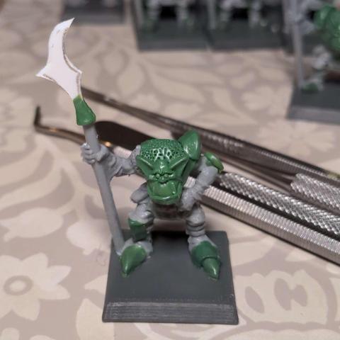 An in progress shot of a plastic model orc with various areas re-sculpted in epoxy putty