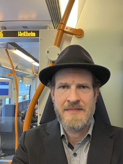 Selfie von Peter Seyferth, der in einem Zug sitzt (mit Hut, wie cool!).