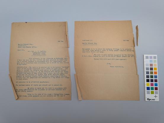 Two pieces of beige brown paper with blue ink. Pieces creased and broken off at corners.