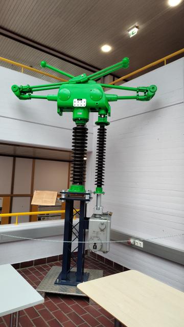 Ausstellungsstück.Schalter für Hochspannung. Ein scherenartiger Schaltarm steht auf einem meterlangen Porzellanisolator. Normalerweise nurin Umspannwerken im freien zu finden.