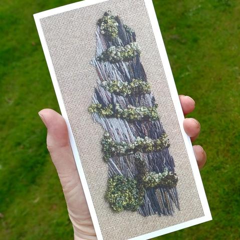 A DL format greeting card held in the hand for scale taken from a stitched artwork depicting a slate quarry
