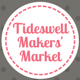 Round logo with Tideswell Makers Market in pink text and stitching around the edge on a grey background
