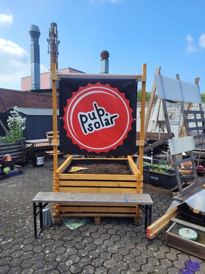 A pub.solar banner hung on the frame of a wooden planter.