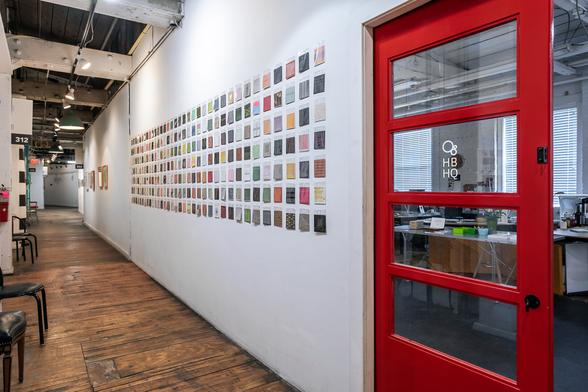 A long wall of 300 drawings for the original showing of my 600 drawings project. Red doors begin the perspective view down a 6 foot wide hallway.