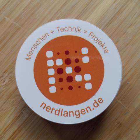 ein Stapel Aufkleber mit der Aufschrift „nerdlangen“ und „Menschen + Technik = Projekte“